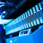 Apple étudierait un serveur IA avec des puces M8 Ultra A detailed view of a blue lit computer server rack in a data center showcasing technology and hardware.