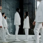 Stuart Fails to Save the Universe saison 2 : date, casting et intrigue A diverse group in white suits face each other in an industrial setting, symbolizing equality.