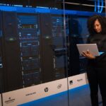 ShinyHunters contourne une mitigation Oracle PeopleSoft A female engineer using a laptop while monitoring data servers in a modern server room.