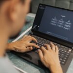 Trump annonce une « AI Force » dont la mission reste floue A focused individual types on a laptop running AI software indoors.