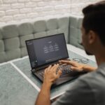 IA dans les PME : choisir un premier projet utile A man working on a laptop in a cozy, modern office space with a focus on technology.