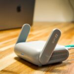 Wi-Fi 7 mesh : le débit ne suffit pas pour choisir A sleek WiFi 6 router with antennas and cable on a wooden desk, perfect for modern home networks.