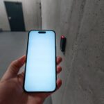 11 failles Android et Apple corrigées : le cas du NFC A smartphone unlocking a secure door using NFC technology in a modern building stairwell.