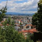 Slovénie - Écosse : heure, chaînes et accès au direct A vibrant cityscape of Ljubljana, Slovenia, framed by lush greenery and a clear sky.