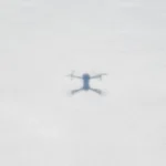 Drone autonome : où commence réellement l'autonomie Blurred drone shadow on a snowy ground, illustrating aerial photography.