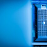 Pourquoi les data centers américains inquiètent davantage Close-up of a modern server unit in a blue-lit data center environment.