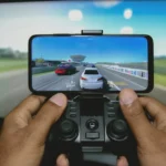 Need for Speed : les épisodes à choisir selon son style Close-up of hands playing a racing game on a mobile device with a controller.