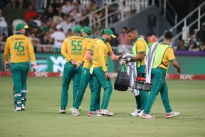Cricket players gather on the field during a match, discussing strategy.