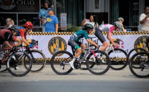 Cyclists racing in Baltimore, Maryland event. Energetic and competitive scene with city backdrop.