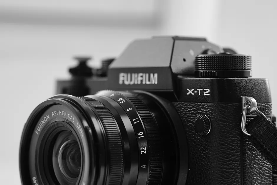Detailed black and white image focusing on a Fujifilm X-T2 camera and lens.