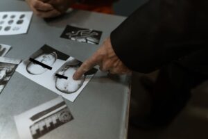 Detective reviewing crime scene photos and fingerprints indoors.