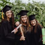 The Love Hypothesis sur Prime Video : Olive et Anh au centre Group of smiling young women graduates posing with diplomas outdoors.