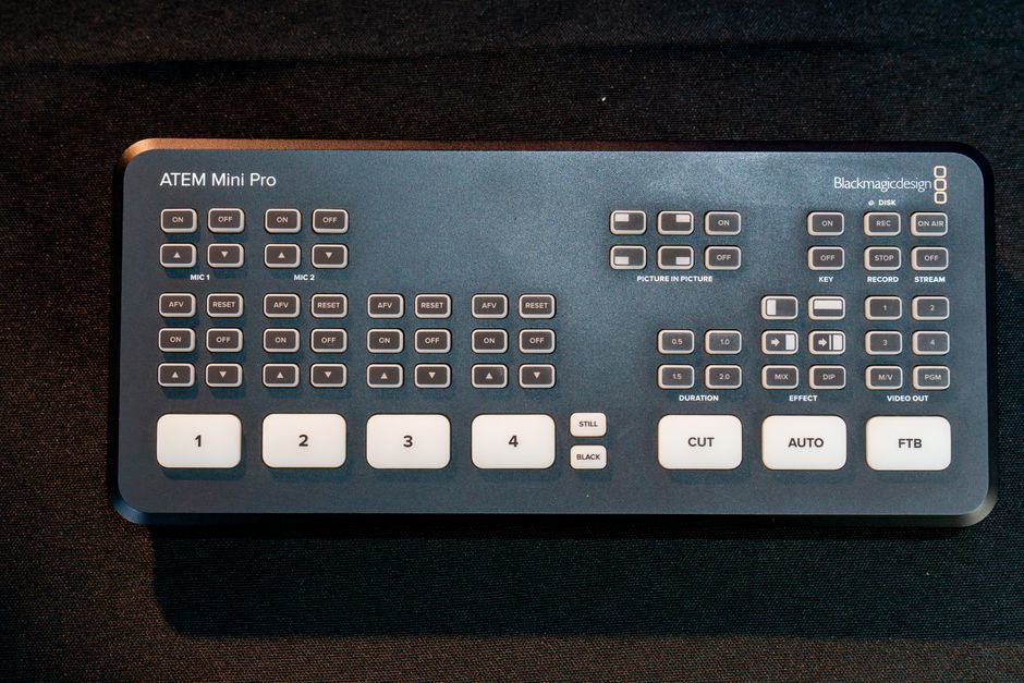 Overhead shot of an ATEM Mini Pro video switcher on a dark surface, showcasing buttons and controls.