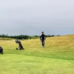 Presidents Cup 2026 : calendrier, équipes et diffusion Two golfers on a lush green course in Skåne, Sweden, enjoying a leisurely game under a cloudy sky.