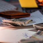 L'IA médicale peut-elle augmenter les coûts hospitaliers? Zloty banknotes and financial paperwork scattered on a desk, representing budgeting and finance.