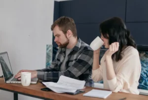 A couple at home, focusing on budgeting and finances with a laptop.