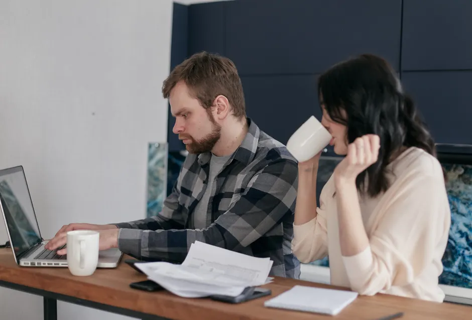 A couple at home, focusing on budgeting and finances with a laptop.