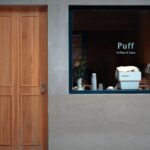 Loewe aura.matic : fonctions et limites à 5 000 euros A modern cafe facade with a wooden door and a window displaying 'Puff Coffee & Cake' in Suzhou, China.