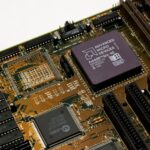 AMD EPYC 9996 : 256 cœurs et 600 W pour les serveurs SP7 Detailed view of a vintage motherboard with an AMD microchip, showcasing intricate circuitry and slots.