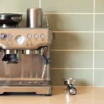 Machine à café Breville en promotion : quel modèle choisir? Modern espresso machine with push buttons and gauge, blending technology and convenience in a stylish kitchen setting.